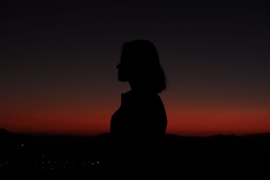 Silhouette of a woman against a vibrant sunset sky in Nevşehir, Türkiye.